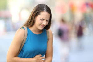 Frau hat Bauchschmerzen wegen Leaky Gut Syndrom