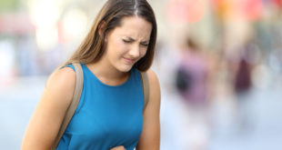 Frau hat Bauchschmerzen wegen Leaky Gut Syndrom
