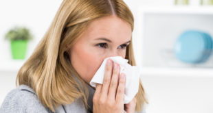 Frau mit Nasennebenhöhlenentzündung putzt sich die Nase